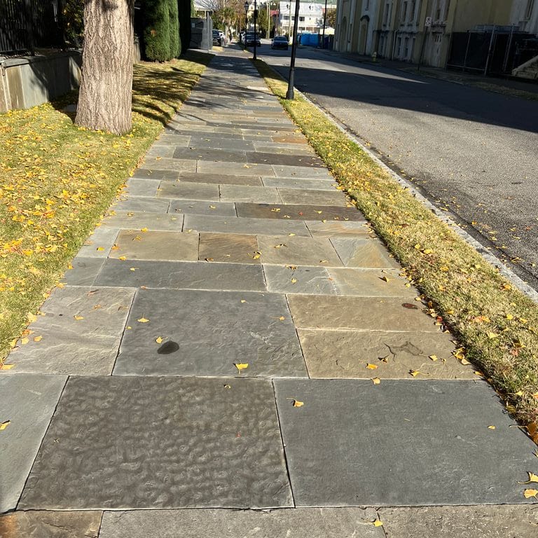 Application image for Reclaimed Bluestone Sidewalk Stones. The image shows this material being used in a path pavers application. The surface finish shown is antiqued. Dominant colors shown are brown, gray and tan. The color mix creates a warm feeling.