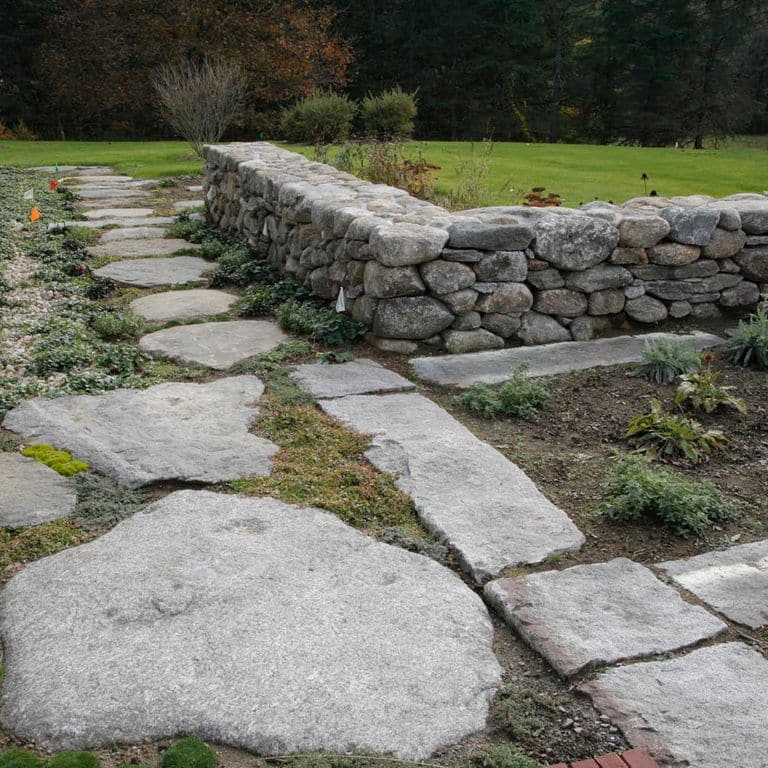 The image shows this material being used in a patio pavers application. The dominant color shown is gray; with a blue secondary. Regular and fine speckled color patterns.
