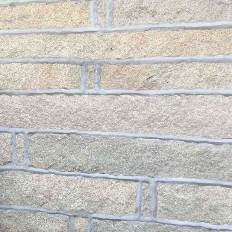 Best close-up image for Reclaimed Granite Plank Veneer. The image shows this material being used in a full bed veneer application. The surface finish shown is . Dominant colors shown are beige and gray; with orange/rust, pink, purple, white, tan and cream secondaries. The color mix creates a cool feeling. Regular and fine speckled color patterns.