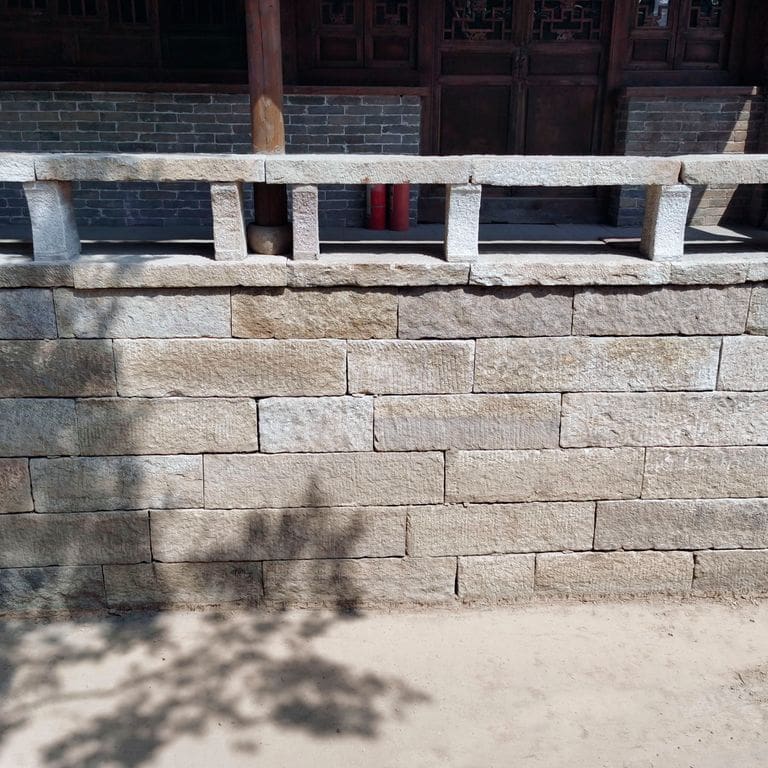 Application image for Reclaimed Granite Plank Veneer. The image shows this material being used in a full bed veneer application. The surface finish shown is . The dominant color shown is gray. Regular color pattern.