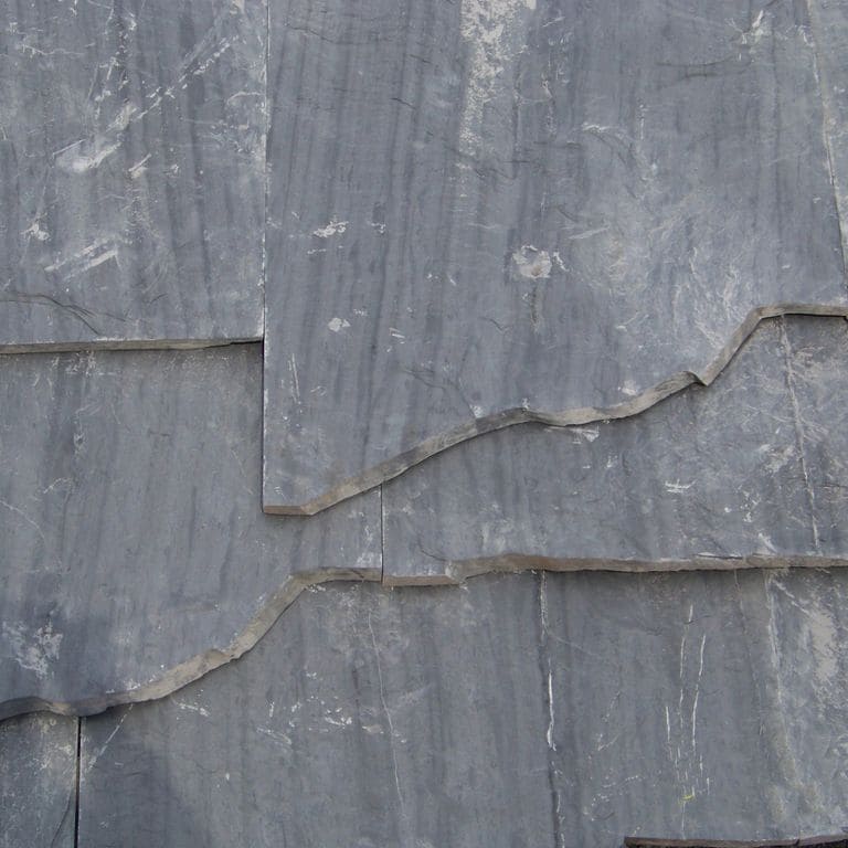 Close-up image for Slate - Vermont Slate - Striated Gray. The surface finish shown is natural cleft. The dominant color shown is gray; with blue and green secondaries. Exhibits "movement" and the color mix creates a cool feeling. Linear and streaked color patterns.