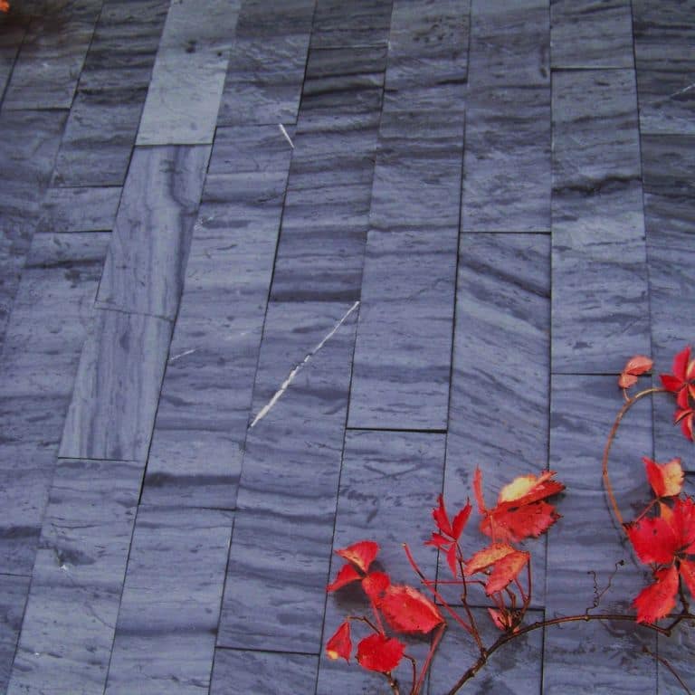 Application image for Slate - Vermont - Striated Gray. The image shows this material being used in a path pavers application. Dominant colors shown are blue and gray; with black and purple secondaries. Regular, linear and streaked color patterns.