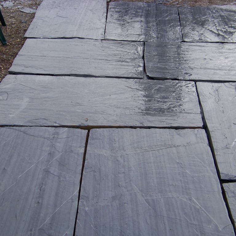 The image shows this material being used in a patio pavers application. Dominant colors shown are blue and gray; with black, purple and white secondaries. The color mix creates a cool feeling. Regular and linear color patterns.