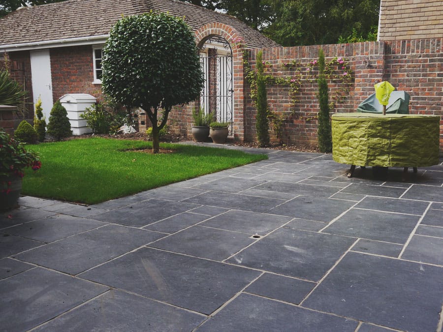 The image shows this material being used in a patio pavers application.