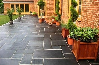 The image shows this material being used in a patio pavers application.