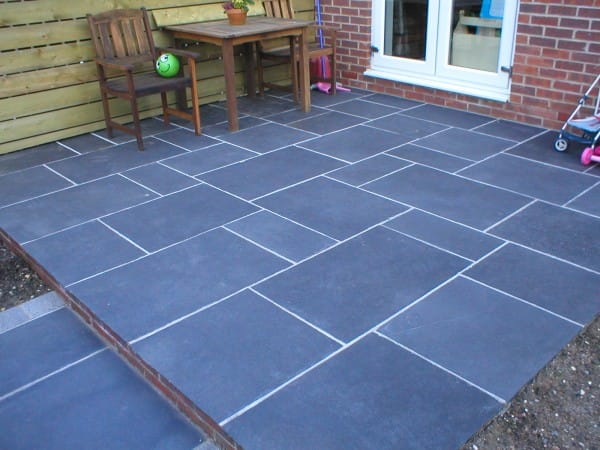 The image shows this material being used in a patio pavers application.