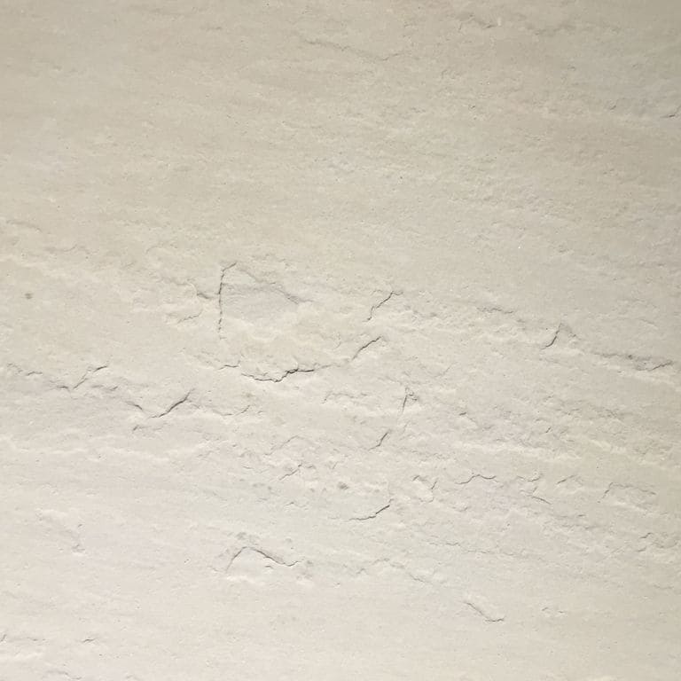 Color/Finish variation image for Portland White Sandstone. The surface finish shown is antiqued. Dominant colors shown are beige and cream; with gray, white and tan secondaries. Exhibits "movement" and the color mix creates a warm feeling. Solid and cloudy color patterns.