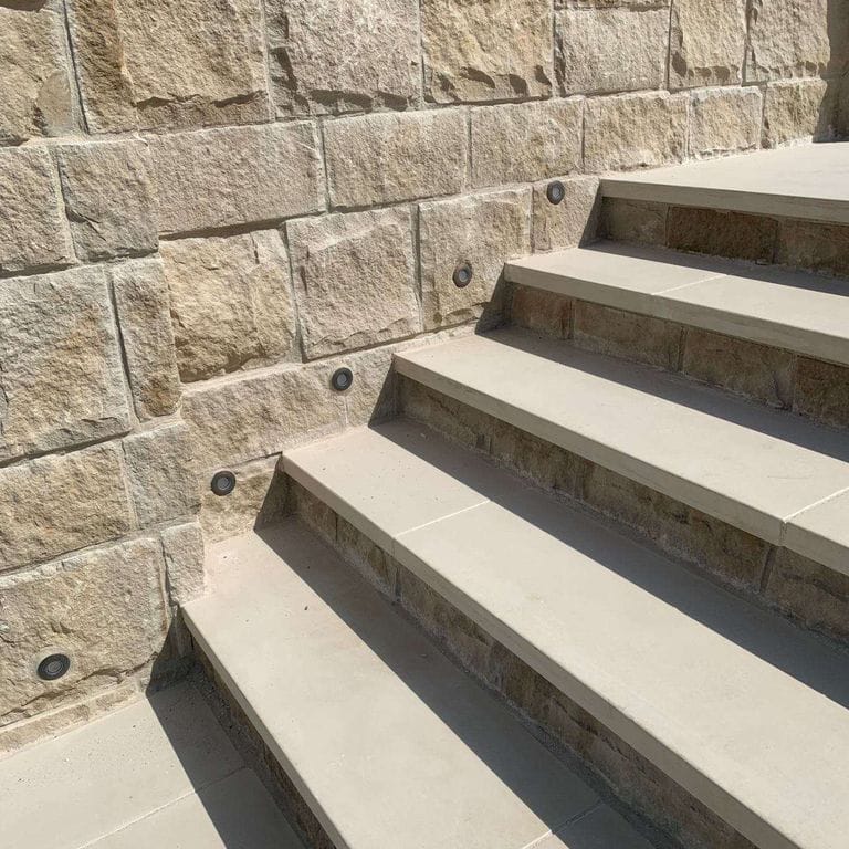 Application image for Portland White Sandstone. The image shows this material being used in a treads application. This is a building and landscape stone for indoor and outdoor residential applications. Suitable for general use, low heat absorption surfaces, high traffic areas and high heel compatibilty situations. Relatively higher in price.