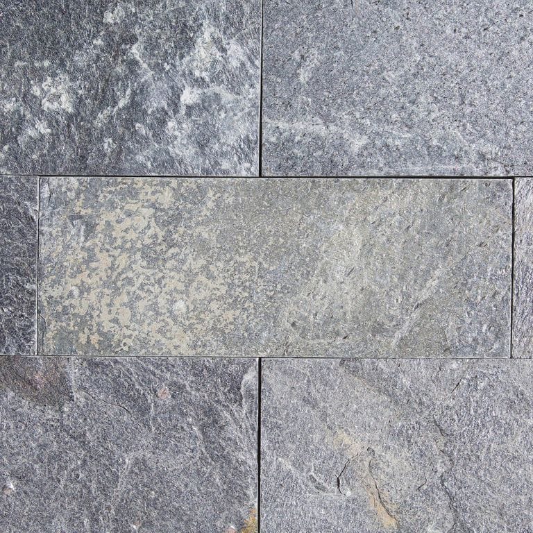 Best close-up image for Quartzite - Amazon. The surface finish shown is split-face with flat plane. The dominant color shown is gray; with blue, brown, green, purple and white secondaries. Exhibits "movement" and the color mix creates a cool feeling. Regular, swirled, blotched and cloudy color patterns. Contains some mica and mineral inclusions.