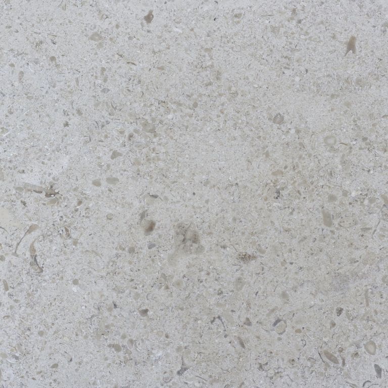 Close-up image for Topa Beige Limestone. The surface finish shown is brushed. The dominant color shown is gray; with beige and white secondaries. Exhibits "movement" and the color mix creates a cool feeling. Regular, speckled and cloudy color patterns. Contains mineral inclusions.