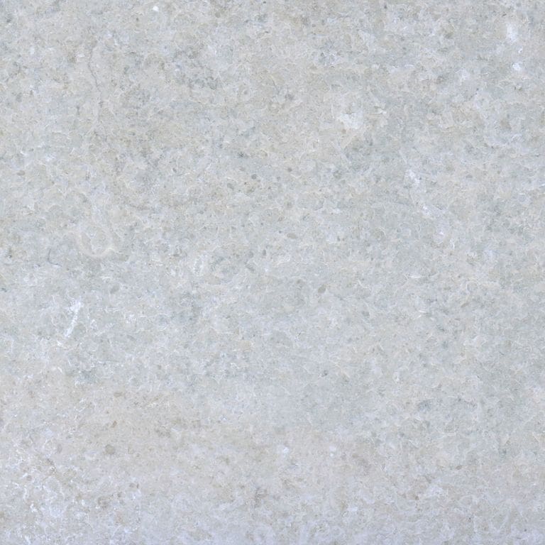 Best close-up image for Limestone - Amaza. The surface finish shown is flamed. Dominant colors shown are blue and gray; with beige, pink and purple secondaries. Exhibits "movement" and the color mix creates a cool feeling. Random and cloudy color patterns. Contains mineral inclusions.