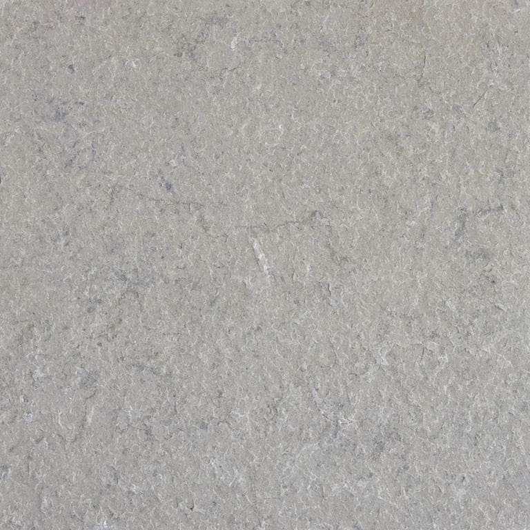 Close-up image for Classimo Sky Limestone. The surface finish shown is flamed. The dominant color shown is gray; with a white secondary. Exhibits "movement" and the color mix creates a cool feeling. Solid, regular and cloudy color patterns.