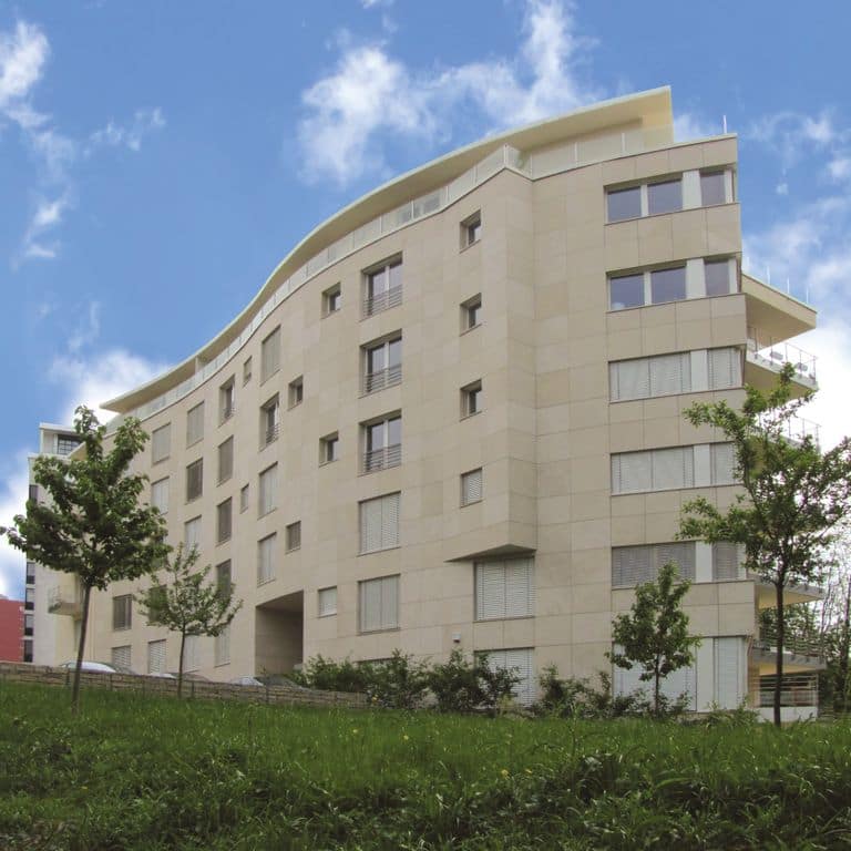 Feature image for Cremos Limestone. The image shows this material being used for full bed veneer and thin veneer. Dominant colors shown are beige, tan and cream. The color mix creates a warm feeling. Solid color pattern.