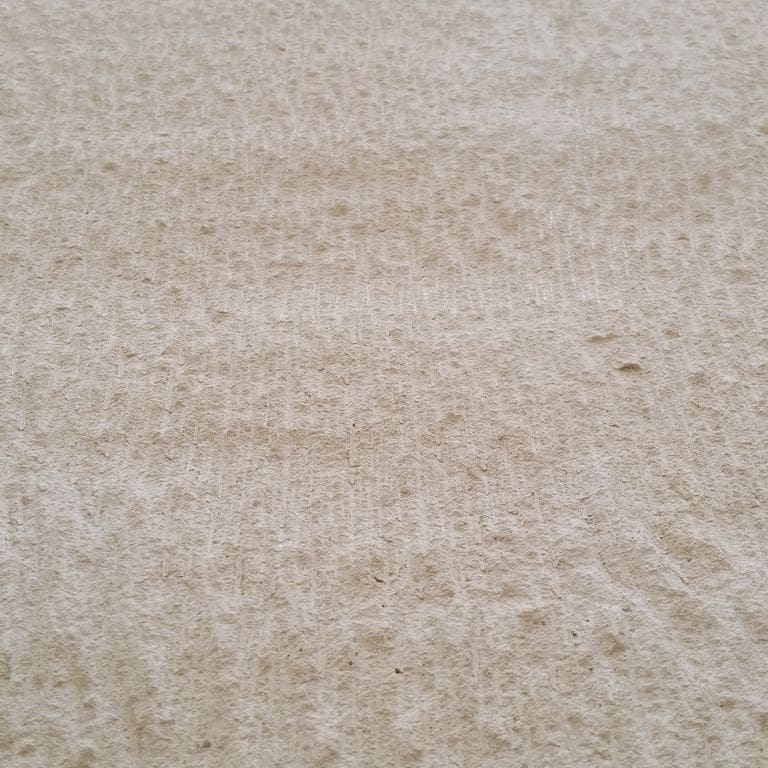 Color/Finish variation image for Portuguese Pacific Beige Limestone. The surface finish shown is chiseled. The dominant color shown is beige; with brown, white and tan secondaries. The color mix creates a warm feeling. Regular color pattern.