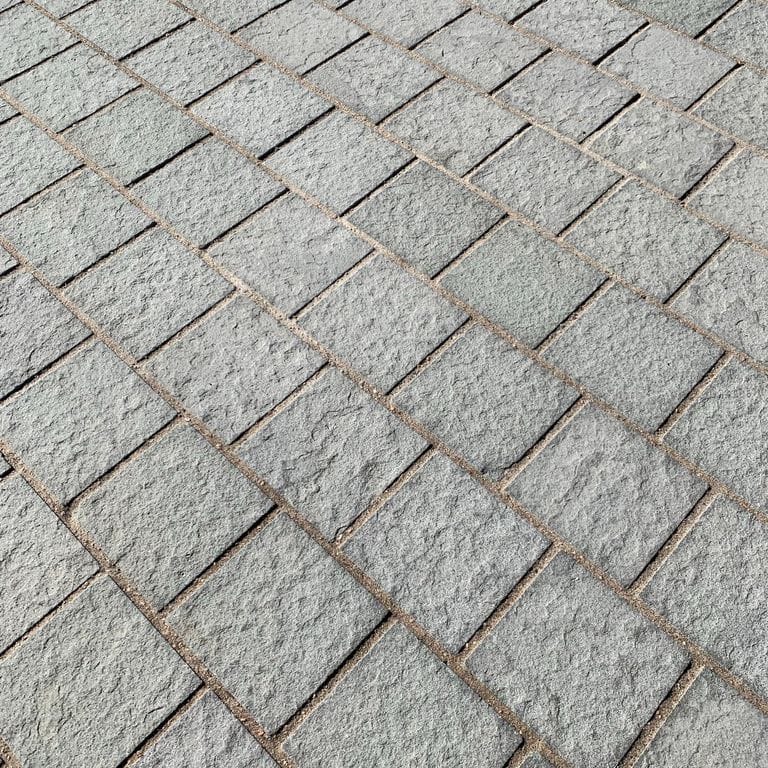 Best close-up image for Italian Bluestone. The image shows this material being used for driveway pavers and patio pavers. The surface finish shown is flamed. Dominant colors shown are blue and gray; with beige, green, pink and white secondaries. Regular, fine speckled and speckled color patterns.