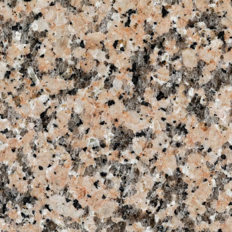 Feature image for Granite - Pink Porrino. The dominant color shown is pink; with black, orange/rust, pink, purple, white and cream secondaries. Exhibits "movement" and the color mix creates a warm feeling. Coarse speckled color pattern. Contains some mica and mineral inclusions.