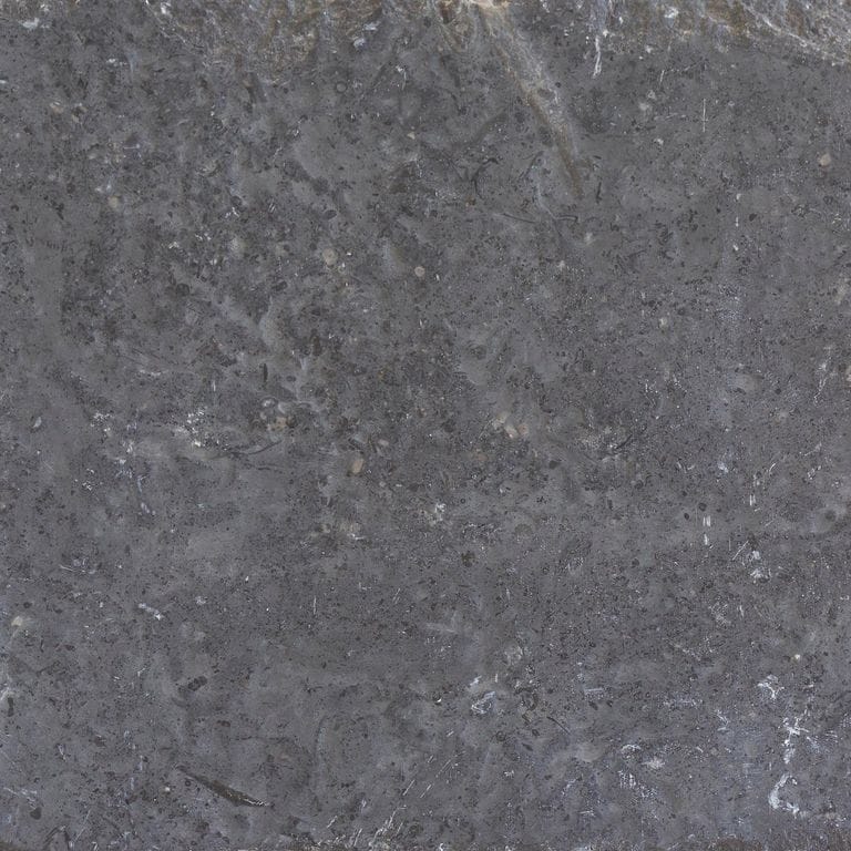 Close-up image for Northern Gray Limestone. The surface finishes shown are brushed and flamed. The dominant color shown is gray; with brown, green and purple secondaries. The color mix creates a cool feeling. Regular and blotched color patterns.