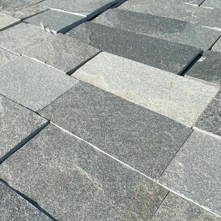 Best close-up image for Greek Quartzite Slate - Grey. The surface finish shown is natural cleft. The dominant color shown is gray; with beige, blue, green, pink, purple and white secondaries. Exhibits "movement" and the color mix creates a cool feeling. Fine speckled and cloudy color patterns.