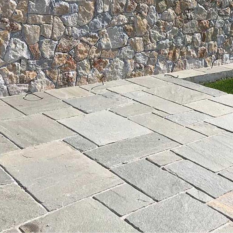 The image shows this material being used in a patio pavers application.