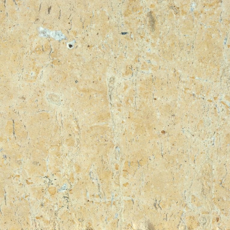 Best close-up image for Limestone - China Buff. The surface finish shown is antiqued. Dominant colors shown are beige, orange/rust, yellow and tan; with brown, orange/rust and cream secondaries. Exhibits "movement" and the color mix creates a warm feeling. Regular, blotched and cloudy color patterns. Contains mineral inclusions.