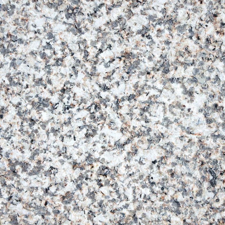 Best close-up image for Yellow Corn Granite. The surface finish shown is flamed. Dominant colors shown are gray and white; with beige, blue, purple, tan and cream secondaries. Coarse speckled color pattern. Contains some mica and mineral inclusions.