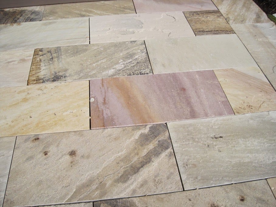 The image shows this material being used in a patio pavers application.