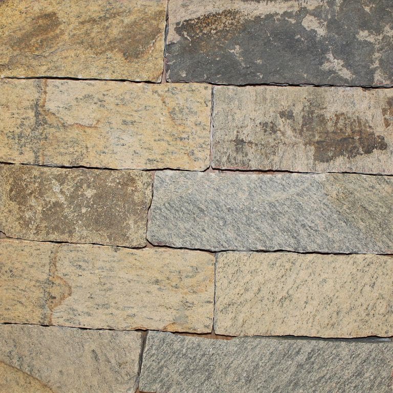 Close-up image for Nutmeg Ridge Granite. The surface finish shown is natural cleft. Dominant colors shown are brown and tan; with beige, gray and orange/rust secondaries. Exhibits "movement" and the color mix creates a warm feeling. Blotched and streaked color patterns.
