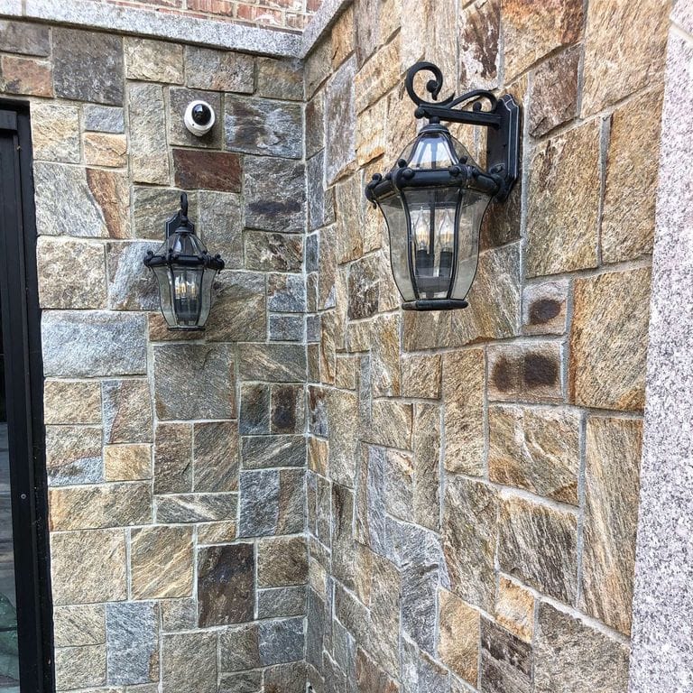 Feature image for Nutmeg Ridge Granite. The image shows this material being used for full bed veneer and thin veneer. Dominant colors shown are gray and tan; with beige, brown, orange/rust, purple, white and cream secondaries. The color mix creates a warm feeling. Random, speckled, blotched and streaked color patterns.