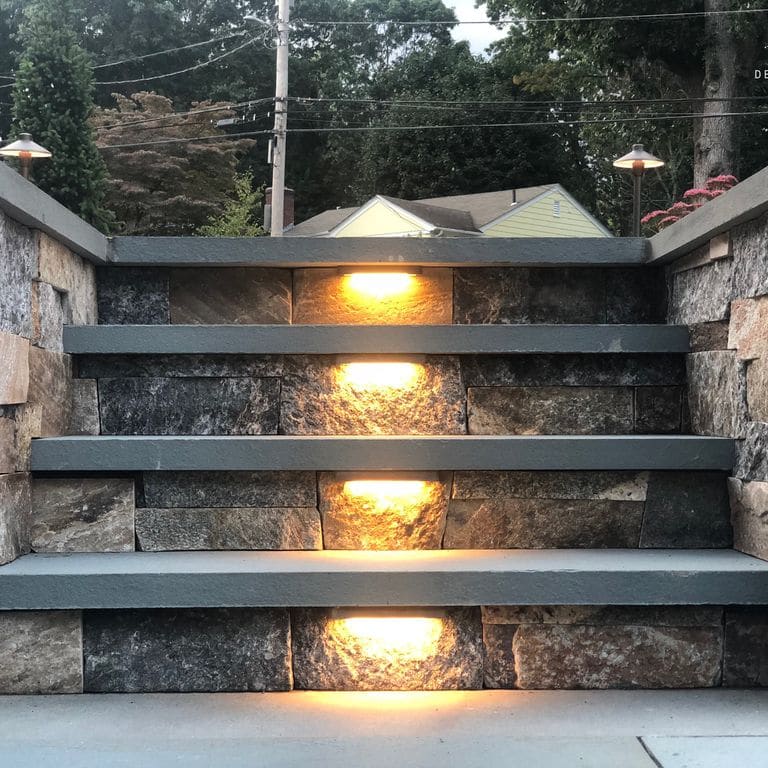 Application image for Granite - Connecticut Blend Thin Veneer. The image shows this material being used for landscape wallstone and treads.