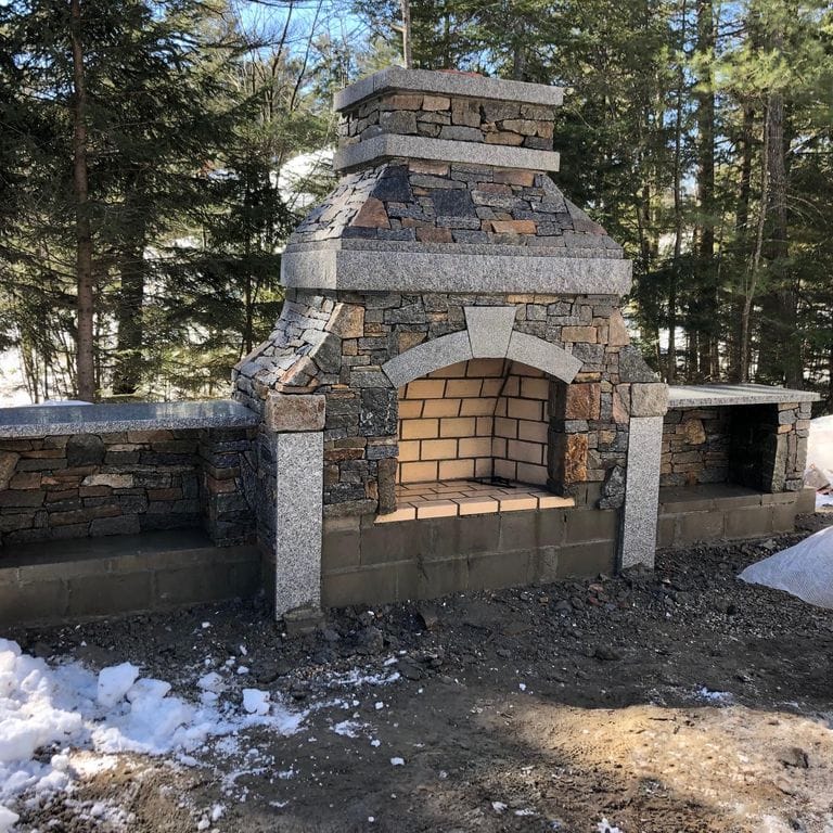Application image for Granite - Connecticut Blend Thin Veneer. The image shows this material being used for fireplace surround, landscape wallstone and thin veneer.
