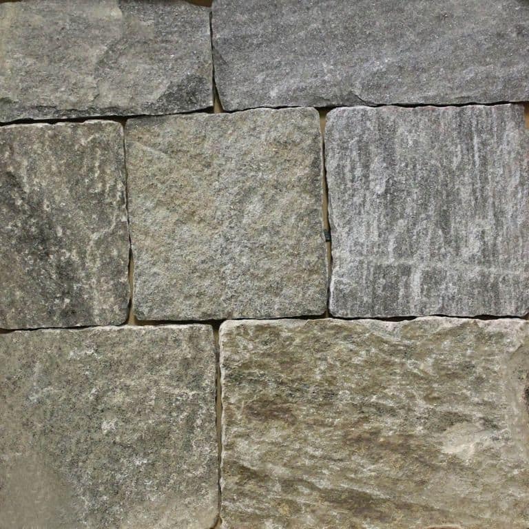 Close-up image for Black Ash Granite. The surface finish shown is split-face with flat plane. Dominant colors shown are green and gray; with brown, orange/rust, purple and tan secondaries. The color mix creates a warm feeling. Regular, streaked and cloudy color patterns.