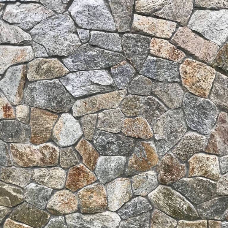 Close-up image for Spruce Mountain Granite. The surface finish shown is natural. The dominant color shown is gray; with beige, brown, green, orange/rust, white and tan secondaries. Exhibits "movement" and the color mix creates a warm feeling. Speckled, streaked and cloudy color patterns.