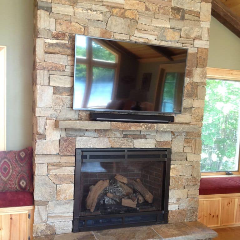 Feature image for Granite - Colonial Tan. The image shows this material being used for fireplace surround, full bed veneer, thin veneer and interior cladding. Dominant colors shown are beige, brown and tan; with gray, orange/rust, purple and cream secondaries. The color mix creates a warm feeling. Random color pattern.