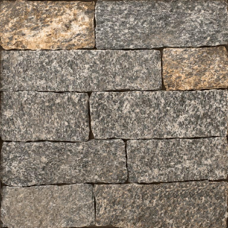 Close-up image for New York Blend Granite. The surface finish shown is split-face. Dominant colors shown are brown, gray and tan; with beige, green, orange/rust and purple secondaries. The color mix creates a warm feeling. Regular, coarse speckled and cloudy color patterns.