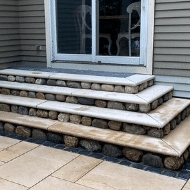 Application image for Cedar Creek River Rounds. The image shows this material being used in a thin veneer application. The surface finish shown is natural. Dominant colors shown are brown and gray; with beige, blue, orange/rust, tan and cream secondaries. Regular color pattern.