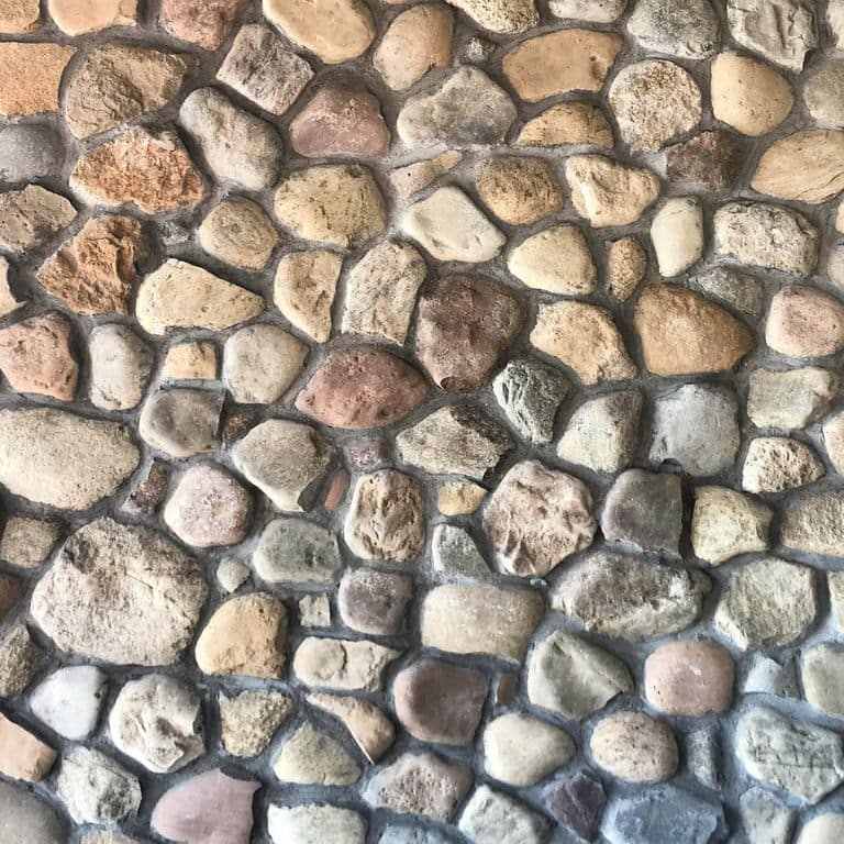 Close-up image for Newport River Rounds. The surface finish shown is natural. Dominant colors shown are beige, brown, gray and tan; with green, orange/rust, purple, white and cream secondaries. The color mix creates a warm feeling. Regular and random color patterns.