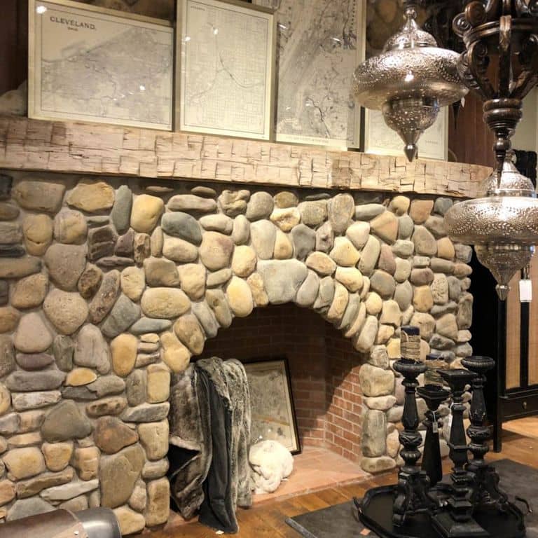 Feature image for River Rounds- Newport. The image shows this material being used for fireplace surround, thin veneer and interior cladding. The surface finish shown is natural. Dominant colors shown are brown, gray, tan and cream; with beige and orange/rust secondaries. The color mix creates a warm feeling. Regular color pattern.