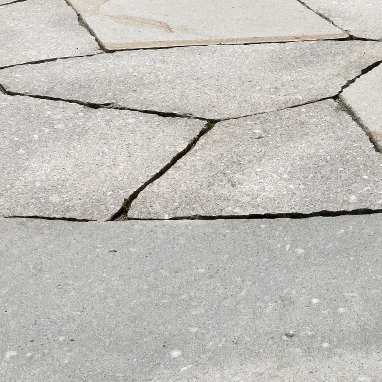 Close-up image for New England Granite Mix. The surface finish shown is flamed. The dominant color shown is gray; with beige, orange/rust, pink, white and cream secondaries. The color mix creates a cool feeling. Speckled color pattern. Contains mineral inclusions.