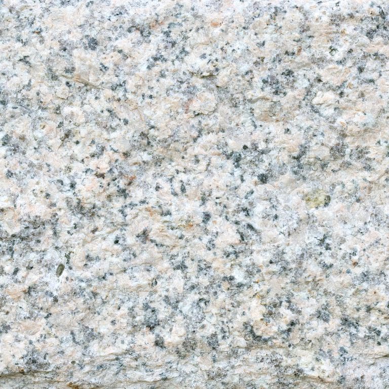 Color/Finish variation image for Granite - Millenium. The surface finish shown is split-face. The dominant color shown is gray; with beige, blue, pink and cream secondaries. The color mix creates a cool feeling. Speckled, blotched and cloudy color patterns.