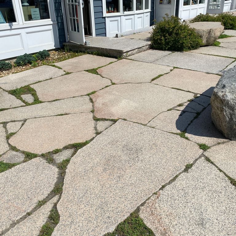 Feature image for Granite - Millenium. The image shows this material being used for patio pavers and public area. Dominant colors shown are beige and gray; with orange/rust, pink and tan secondaries. Exhibits "movement" and the color mix creates a warm feeling. Speckled and coarse speckled color patterns.