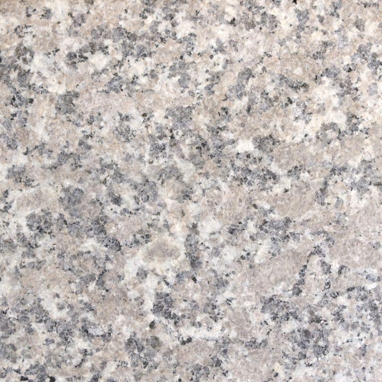 Best close-up image for Deer Isle Granite. The surface finish shown is flamed. Dominant colors shown are beige, gray and pink; with pink, purple, white and cream secondaries. The color mix creates a warm feeling. Blotched and coarse speckled color patterns.