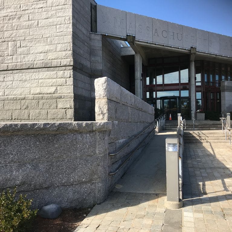 Feature image for Deer Isle Granite. The image shows this material being used in a full bed veneer application. The surface finish shown is split-face. The dominant color shown is gray. The color mix creates a cool feeling.