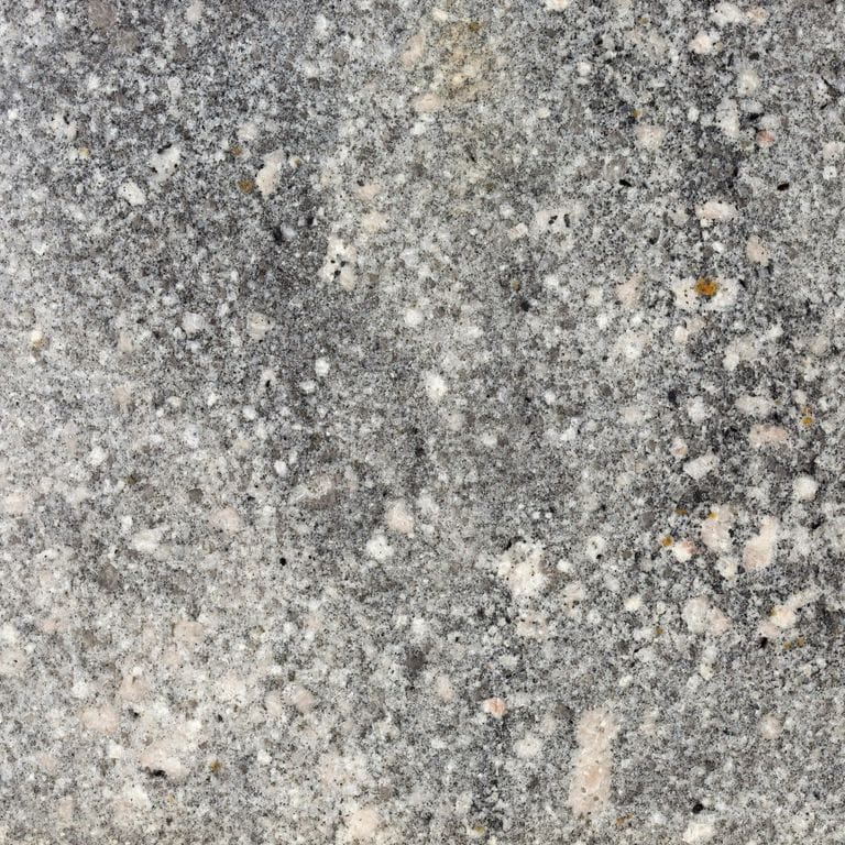 Close-up image for Fancy Beige Granite. The surface finish shown is polished. The dominant color shown is gray; with beige, black, brown, green, pink, purple, white and cream secondaries. Exhibits "movement". Random, coarse speckled and blotched color patterns. Contains mineral inclusions.