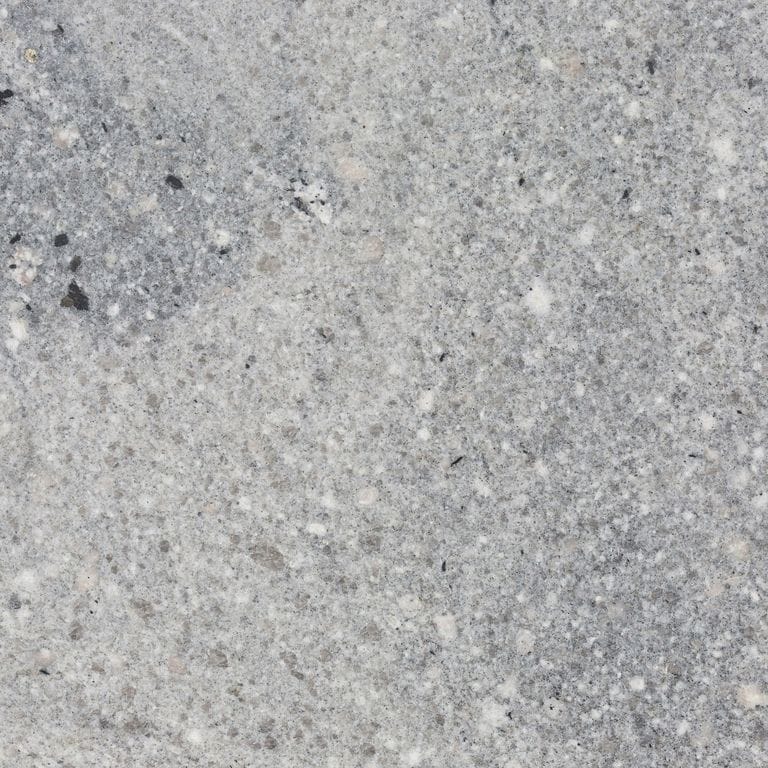 Close-up image for Fancy Blue Granite. The surface finish shown is honed. The dominant color shown is gray; with beige and white secondaries. Exhibits "movement" and the color mix creates a cool feeling. Random, speckled and coarse speckled color patterns. Contains mineral inclusions.