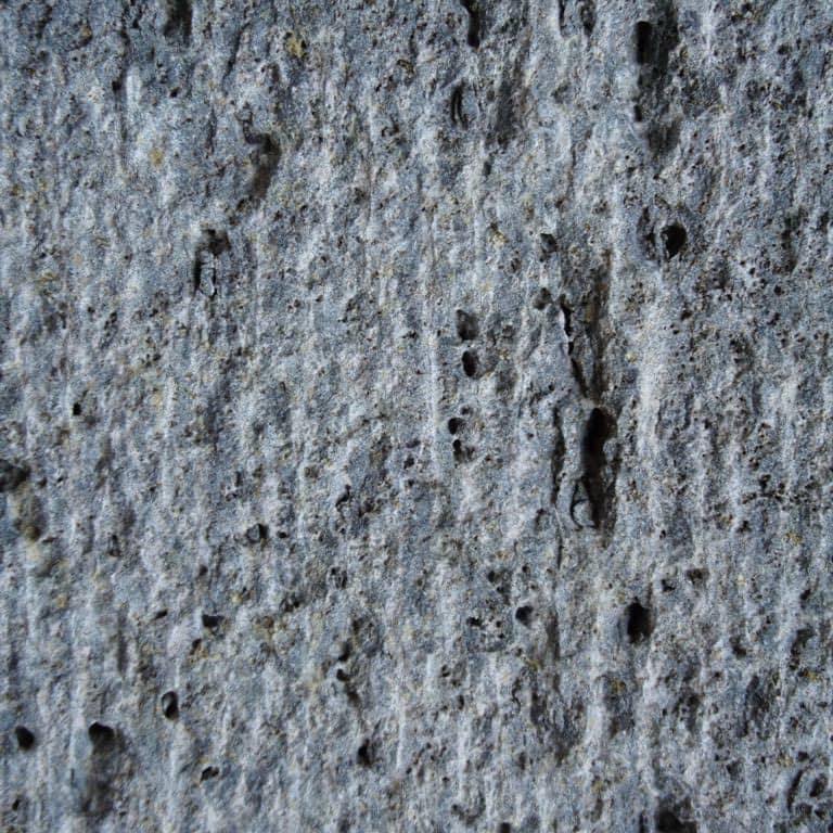 Color/Finish variation image for Ankar Lava Basalt. The surface finish shown is adze. Dominant colors shown are blue and gray; with black and green secondaries. The color mix creates a cool feeling. Linear, random and cloudy color patterns.