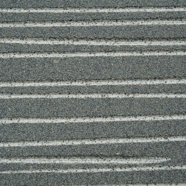 Color/Finish variation image for Ankar Gray Basalt. The surface finish shown is chiseled. Dominant colors shown are green and gray; with blue, brown and white secondaries. Exhibits "movement" and the color mix creates a cool feeling. Fine speckled and linear color patterns.