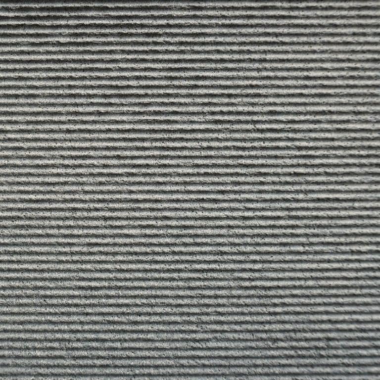 Color/Finish variation image for Ankar Gray Basalt. The surface finishes shown are grooved and sand blasted. The dominant color shown is gray. The color mix creates a cool feeling. Regular and linear color patterns.
