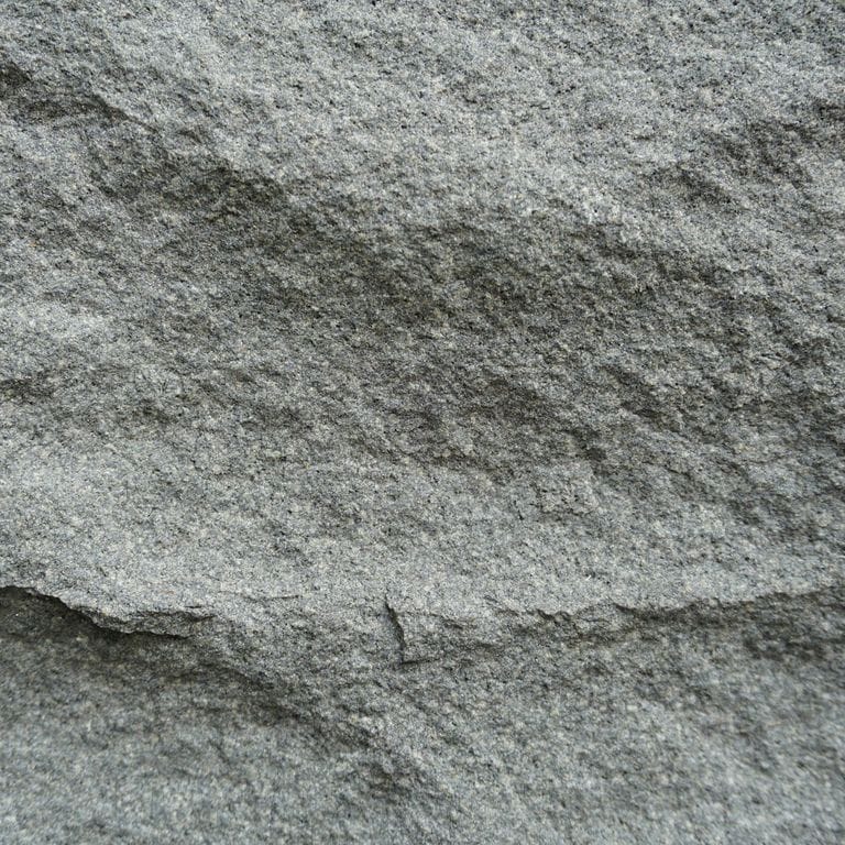 Close-up image for Ankar Gray Basalt. The surface finish shown is split-face with rough plane. Dominant colors shown are green and gray. The color mix creates a cool feeling. Regular and fine speckled color patterns.