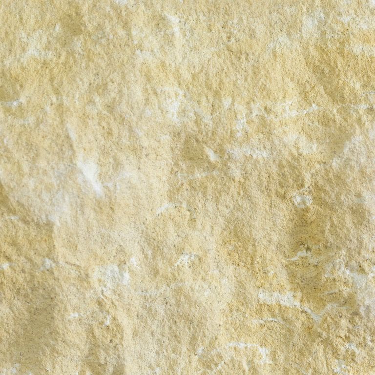 Color/Finish variation image for Limestone - Northern Buff. The surface finish shown is split-face. Dominant colors shown are beige, yellow and tan; with orange/rust and cream secondaries. Exhibits "movement" and the color mix creates a warm feeling. Blotched and random color patterns.