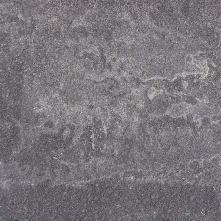 Close-up image for Bluestone Flamed Surface - Lilac. The surface finishes shown are brushed and flamed. Dominant colors shown are gray and purple. Exhibits "movement" and the color mix creates a cool feeling. Random, blotched and swirled color patterns.